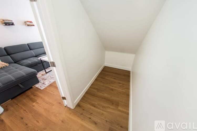 A hallway with a wooden floor and white walls.