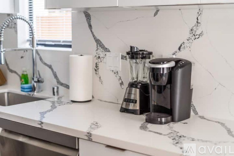 A kitchen counter with a coffee maker and a blender on it.