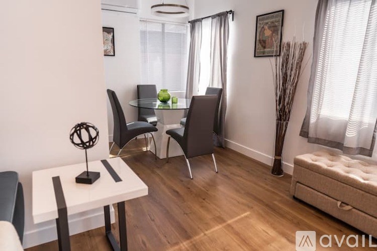 A modern living room with a white table and black chairs.