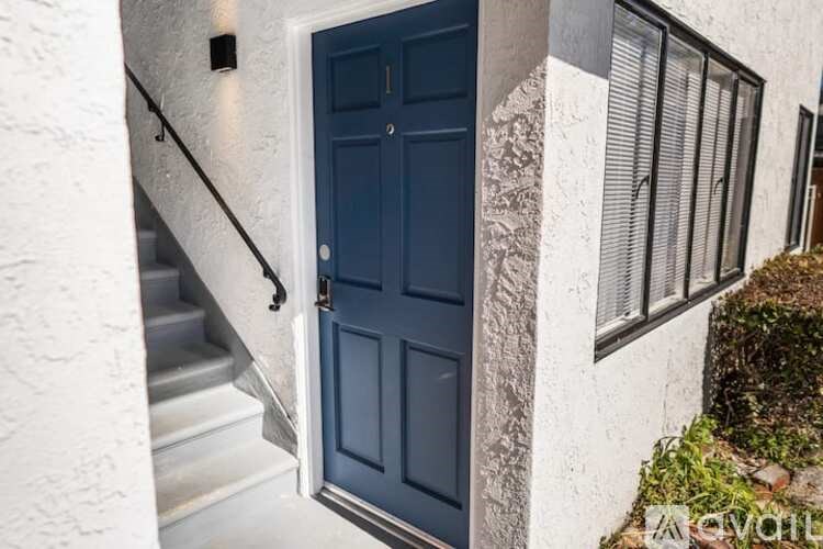 A dark blue door is open to a stairway.