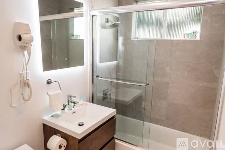 A bathroom with a toilet, sink, and shower.