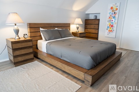 A bedroom with a large bed and two nightstands with lamps.