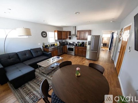 A living room with a black couch and a wooden table.