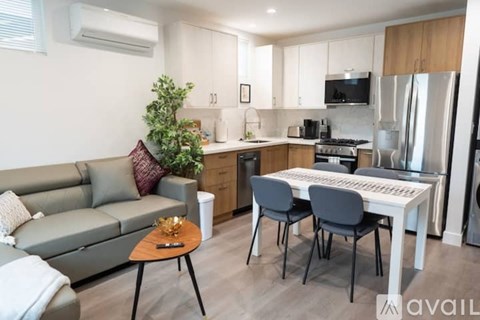 A modern kitchen with a grey sofa and a dining table set up.