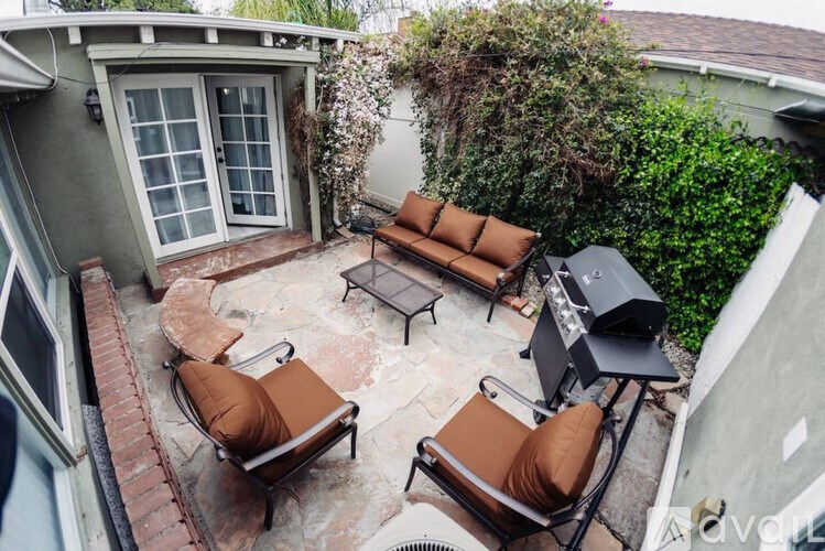A patio with a table and chairs and a grill.