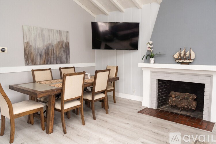 A dining room with a fireplace and a painting on the wall.