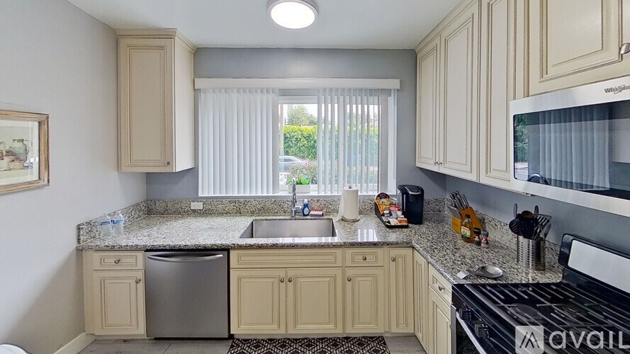 A kitchen with beige cabinets and granite countertops.