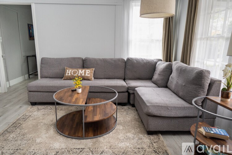 A grey sectional sofa with a coffee table in the middle of a living room.