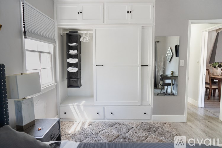 A modern living room with a grey sofa and a white cabinet.