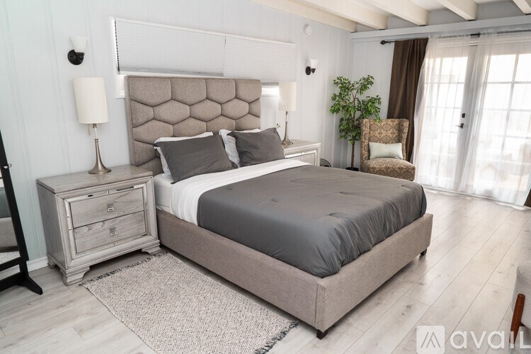 A bedroom with a large bed and a wooden floor.