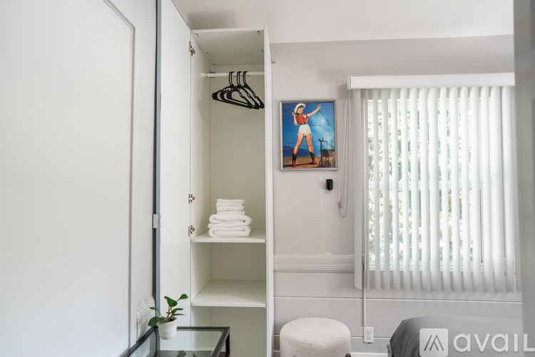 A bathroom with a glass table and a painting of a woman on the wall.