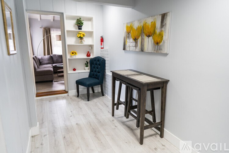 A room with a blue chair and a wooden table.