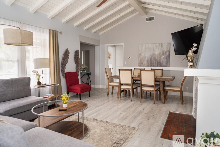 A living room with a grey sofa, a wooden coffee table, and a television.