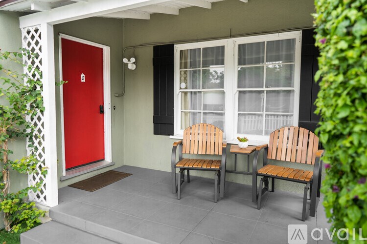 Two wooden chairs are placed on a porch.