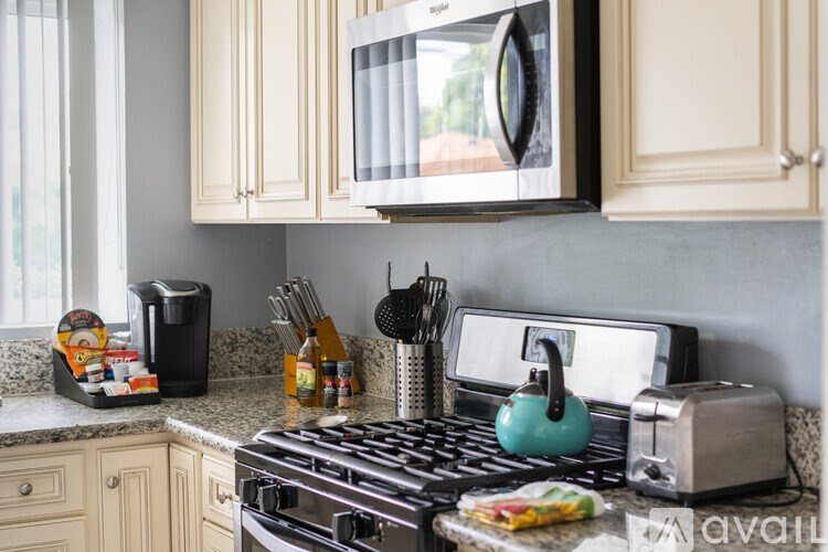 A kitchen with a stove, toaster, and a microwave.