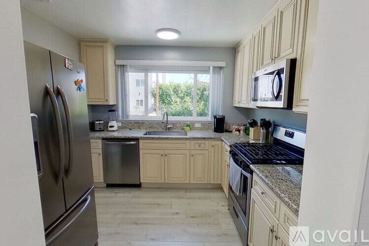 A kitchen with a refrigerator, microwave, and oven.