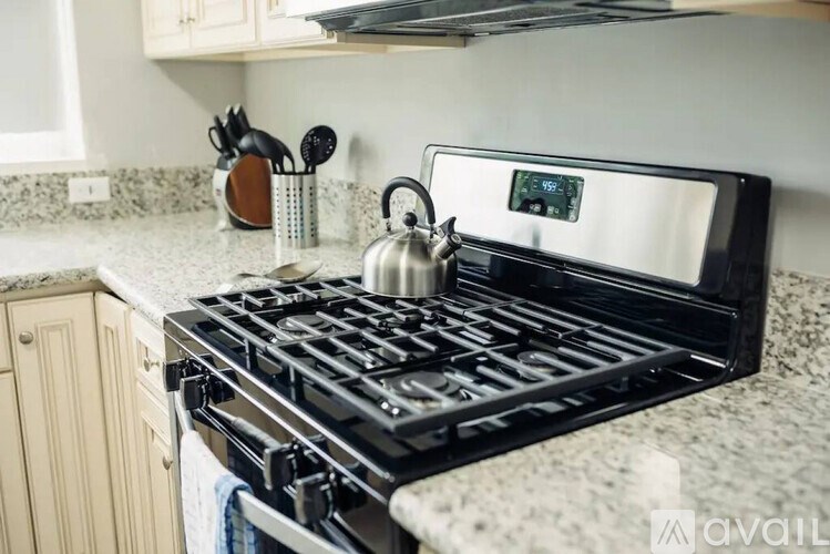 A black stove top with a kettle on it.