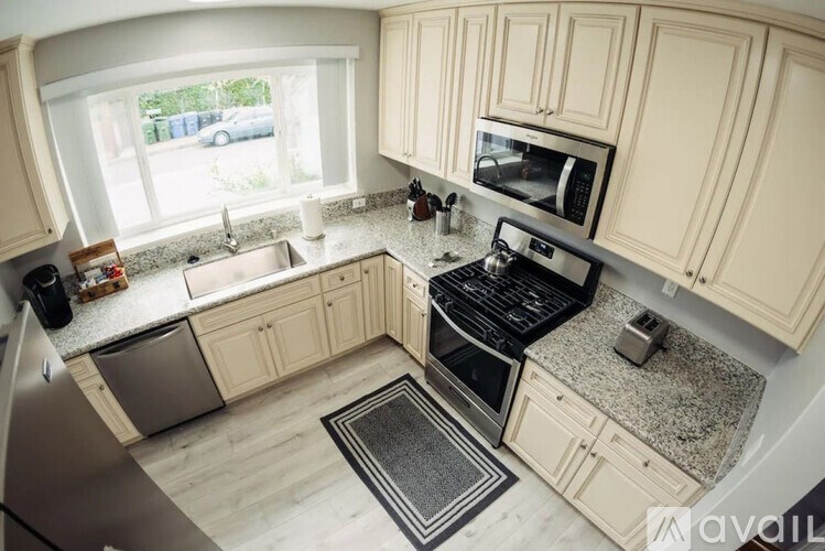 A kitchen with a black stove top oven and a window.