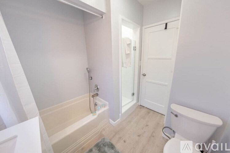 A white bathroom with a tub and toilet.