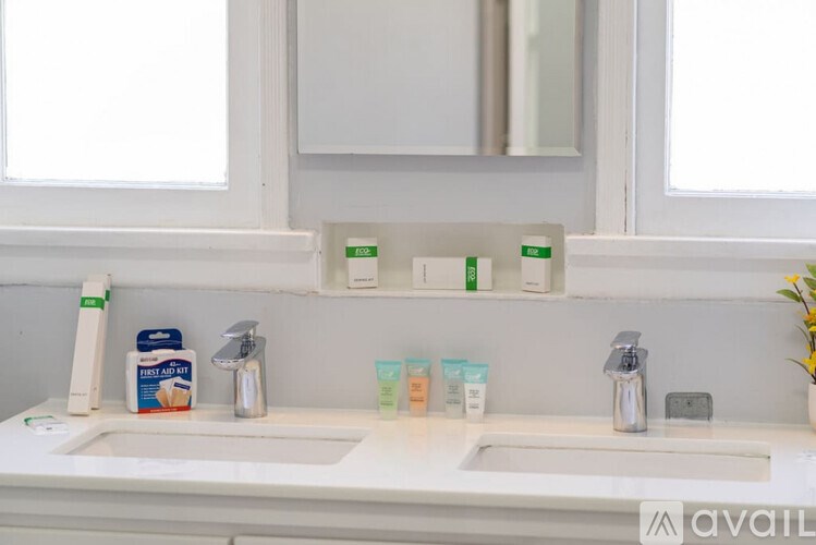 A bathroom with two sinks and a mirror above them.