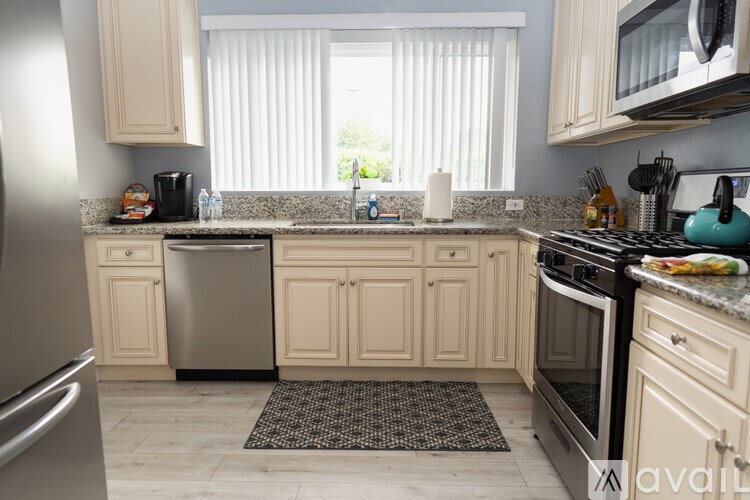 A kitchen with a refrigerator, oven, and microwave.