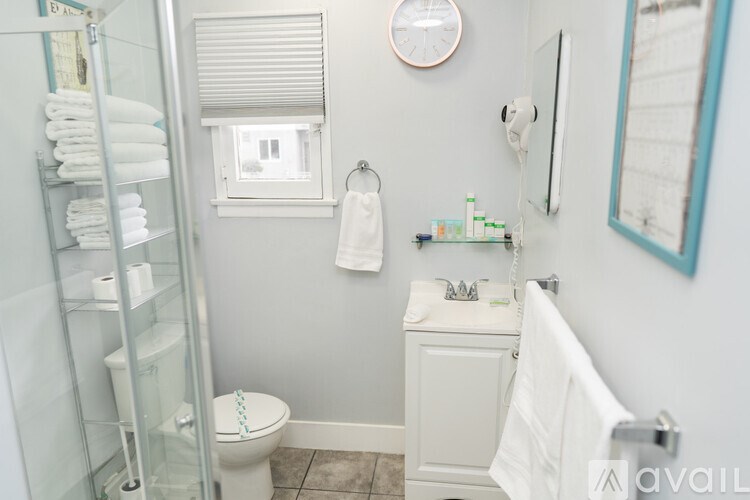 A bathroom with a toilet, sink, and a window with blinds.