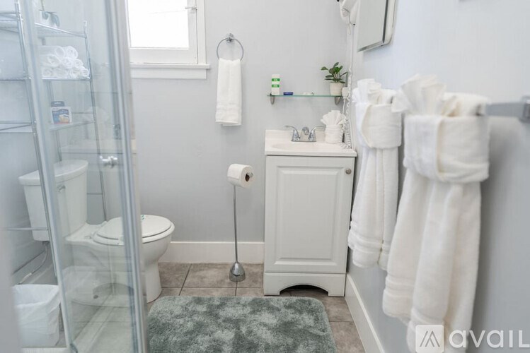 A bathroom with a toilet, sink, and towels.