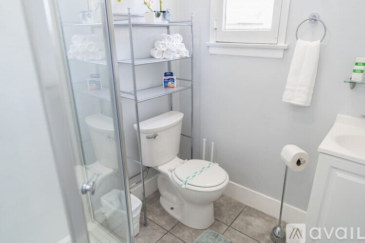 A white toilet is in a bathroom with a glass shower door.
