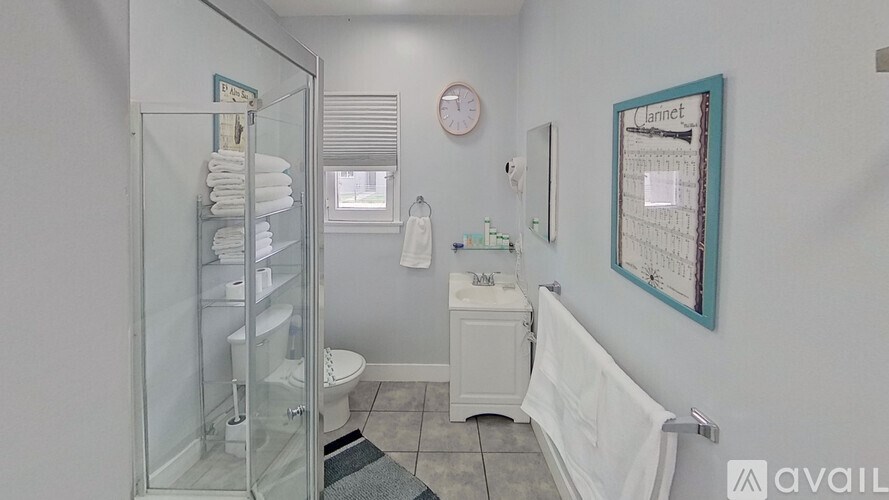 A bathroom with a toilet, sink, and shower.