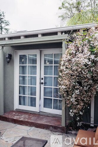 A white door with a glass panel is on a grey building.