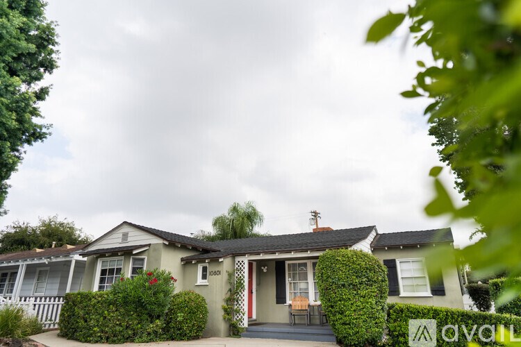 A house with a red door and a sign that says "available" in the front yard.