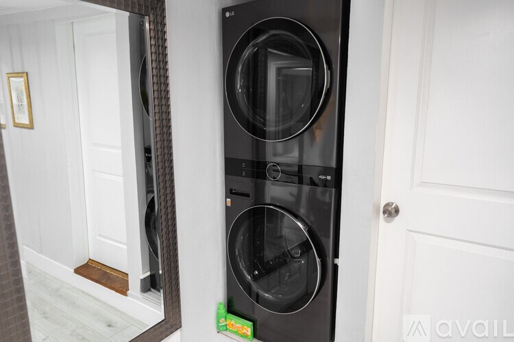 A black front loading washing machine in a white door.