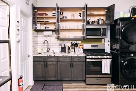 A kitchen with a black oven and a white door.
