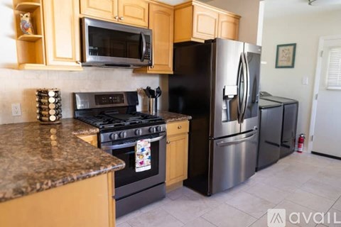 A kitchen with a black refrigerator and stove.