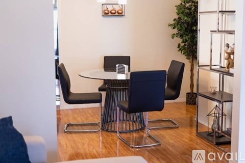 A modern dining room with a glass table and chairs.