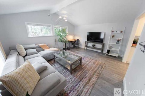 A living room with a grey sofa and a glass coffee table.