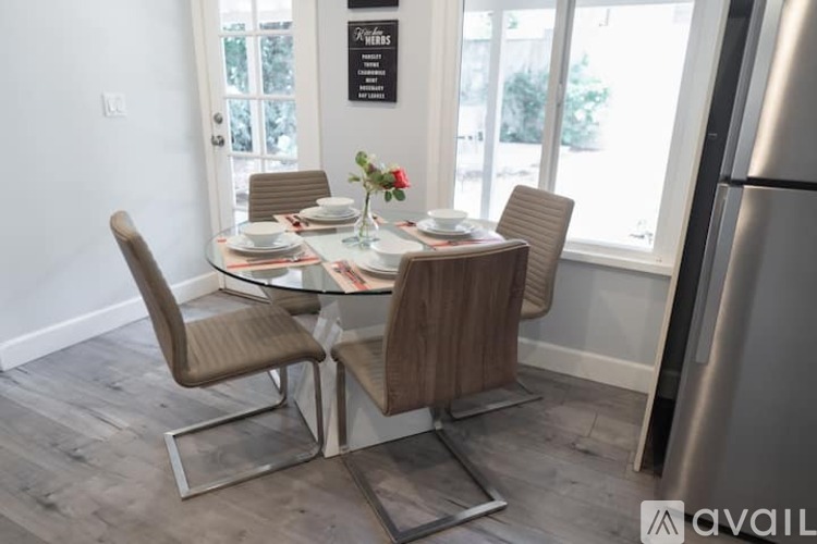A modern dining room with a glass table and chairs.