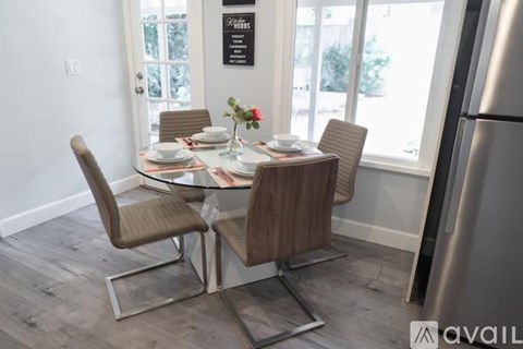 A modern dining room with a glass table and chairs.