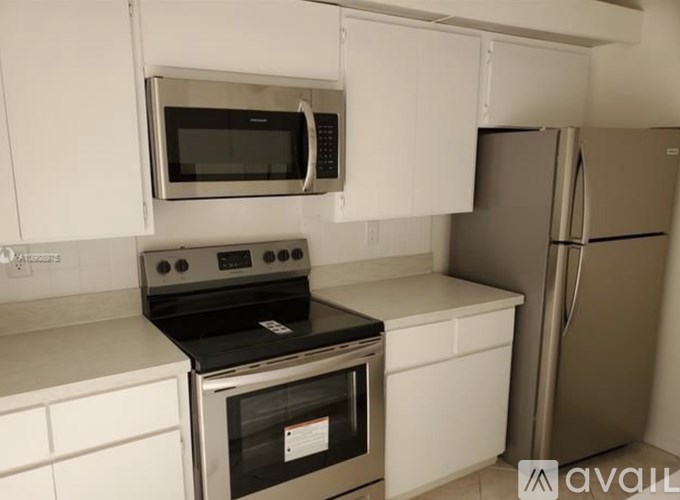 A kitchen with a stove, microwave, and refrigerator.