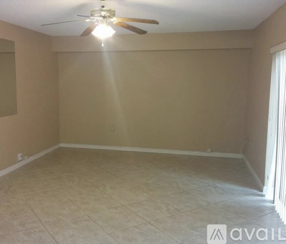 A room with a ceiling fan and tiled floor.