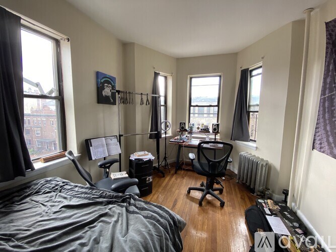 A bedroom with a bed, desk, and chair.