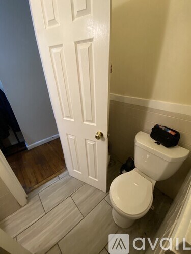A white toilet in a small bathroom with a white door.