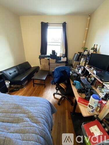 A room with a bed, a couch, a desk, and a chair.