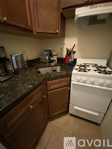 A kitchen with a white stove and wooden cabinets.