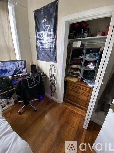 A room with a black chair and a black banner on the wall.