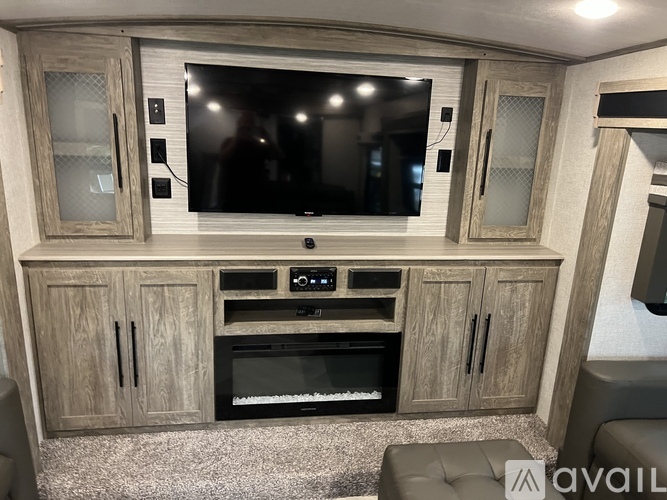 A modern living room with a television, a built-in oven, and a cabinet.