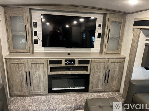 A modern living room with a television, a built-in oven, and a cabinet.