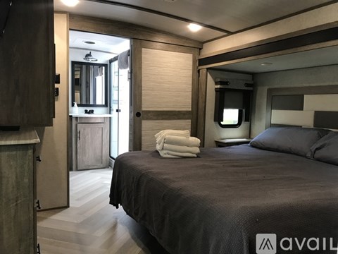 A bedroom with a bed, a mirror, and a cabinet.