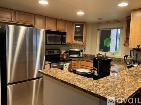 A kitchen with a granite countertop and stainless steel appliances.