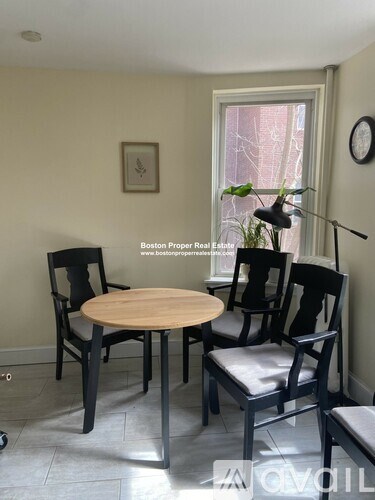 A dining room with a table and chairs.
